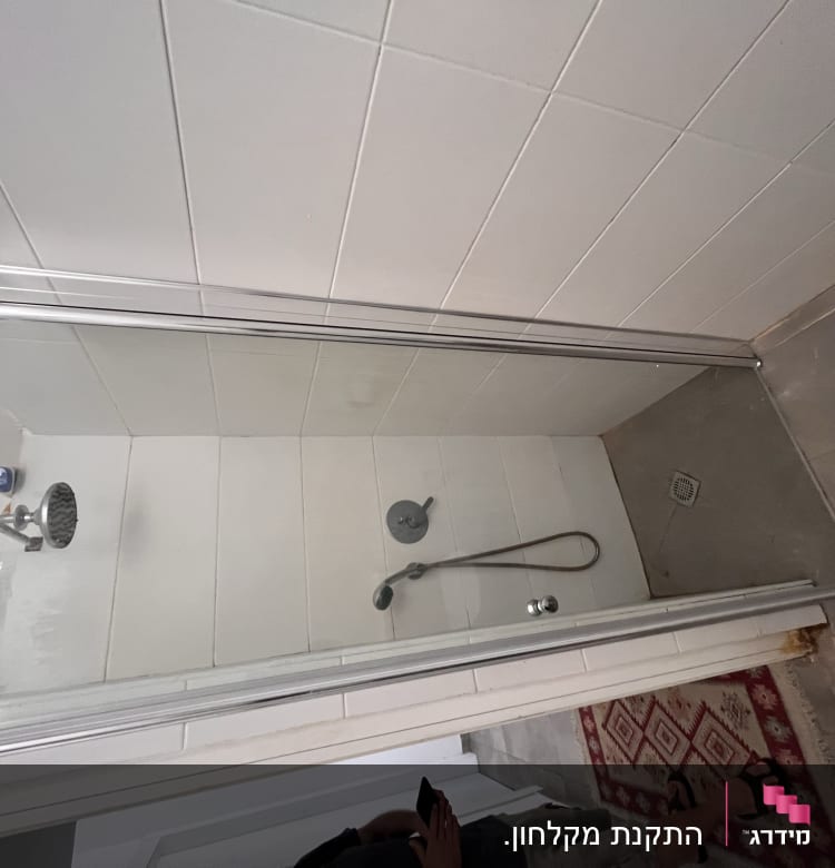 מקלחת עם ראש מקלחת ודלת זכוכית